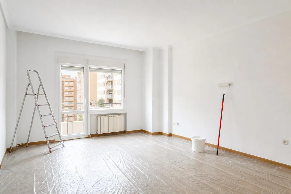 Salón recién pintado en un piso de Zaragoza, con rodillo y escalera de pintor